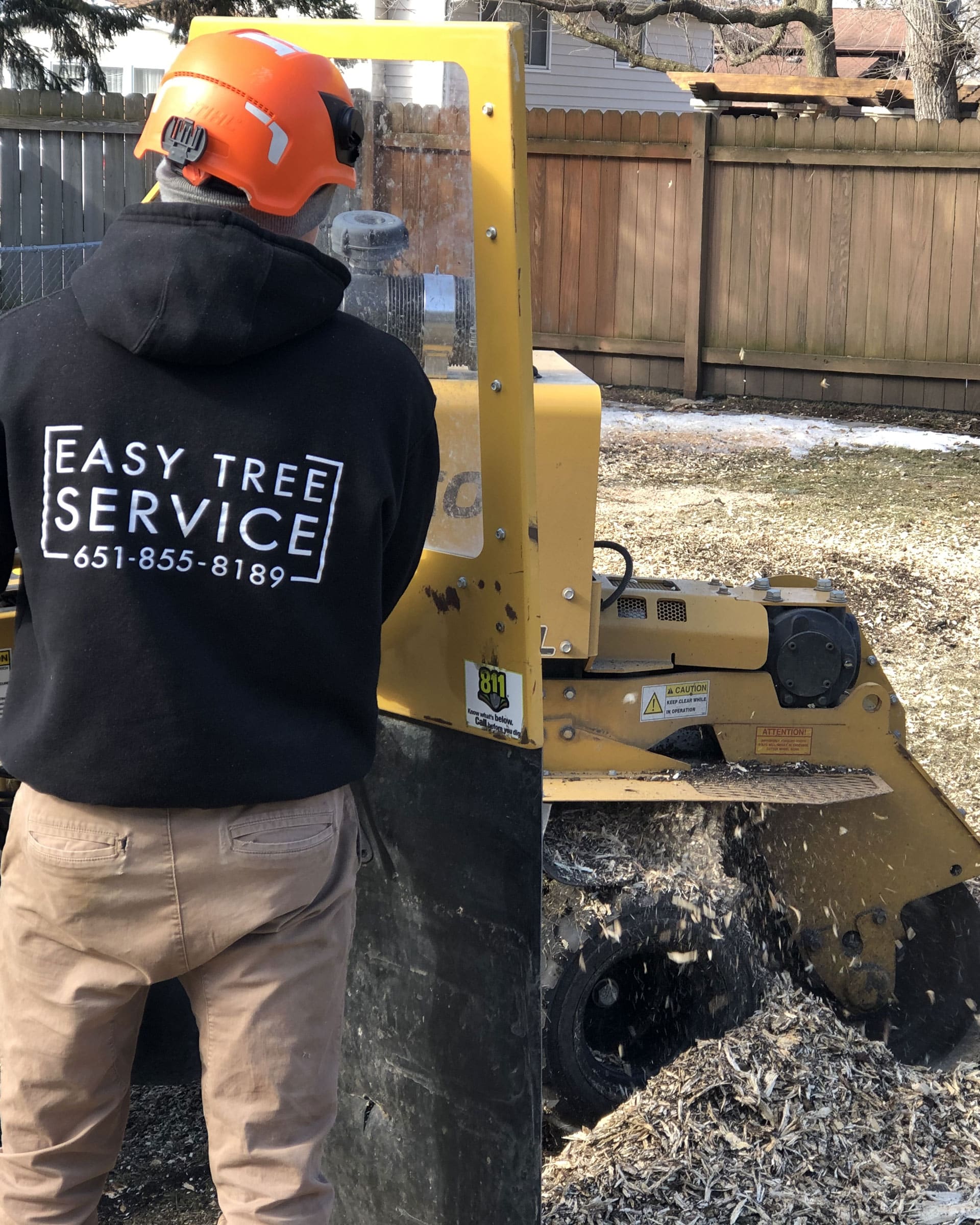 easy tree service worker grinding a stump